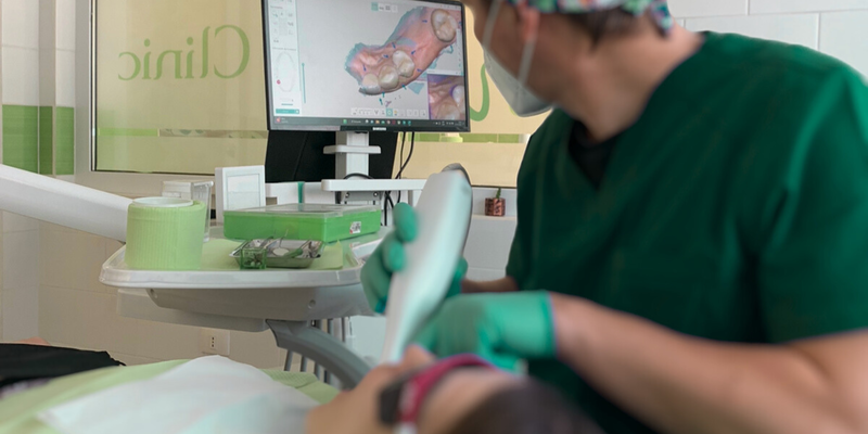 Un especialista de Som Clinic escaneando la boca de un paciente con el escáner intraoral 3Shape, con el modelo 3D en pantalla